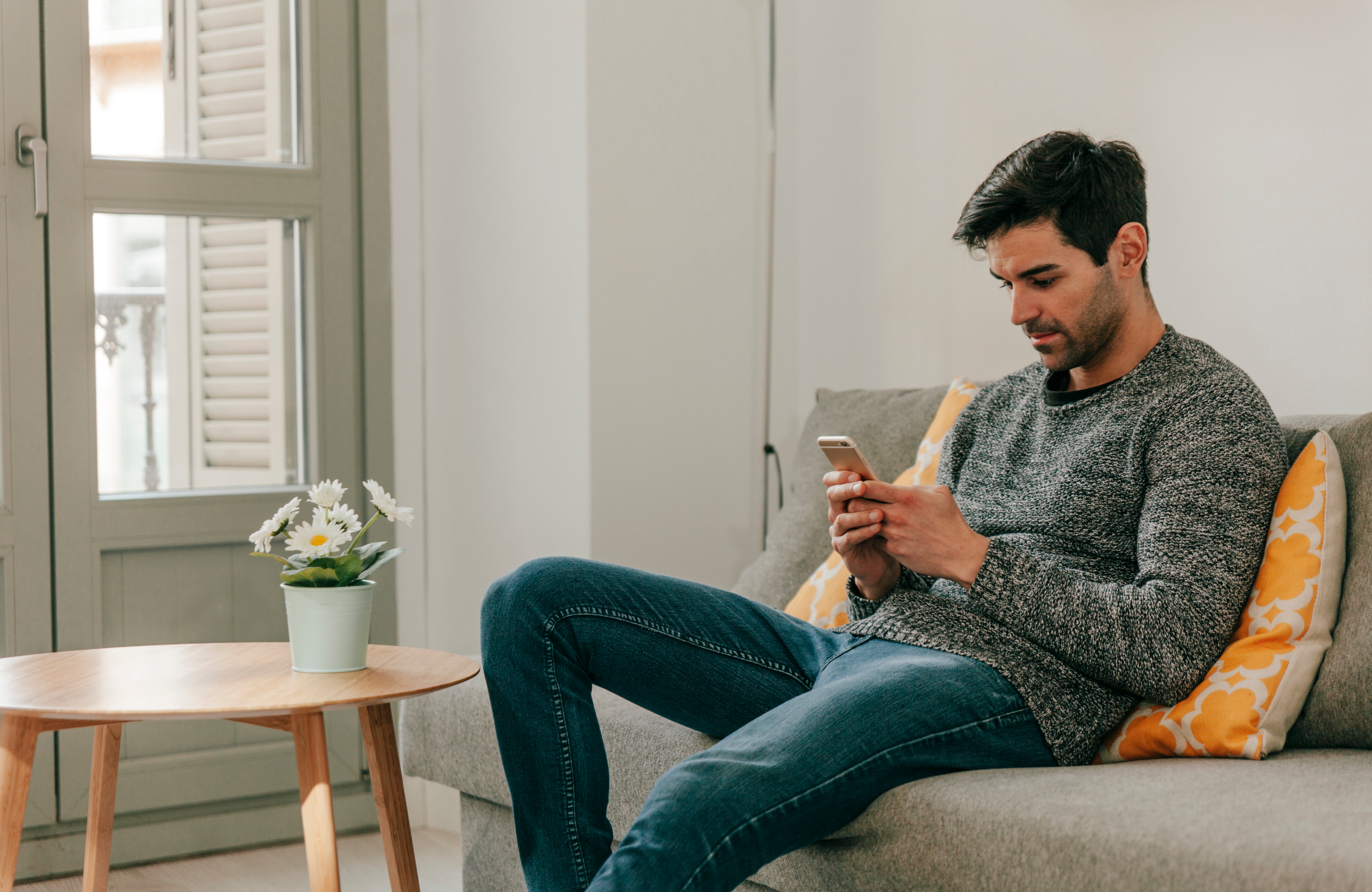 
  'Hombre descansando en sofa con el teléfono'
